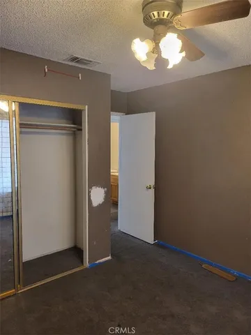 a view of a kitchen with refrigerator and white cabinets