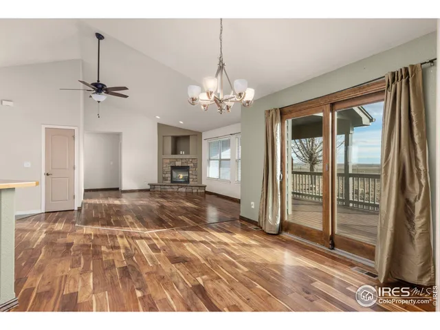 a view interior of a house with wooden floor a ceiling fan and windows