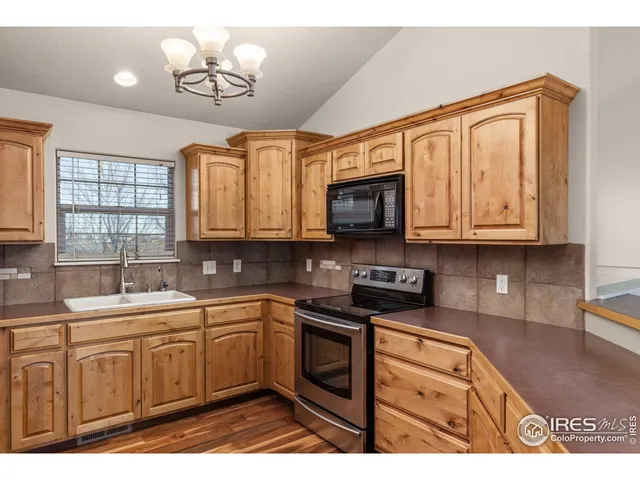 a kitchen with stainless steel appliances granite countertop a sink a stove cabinets and a microwave