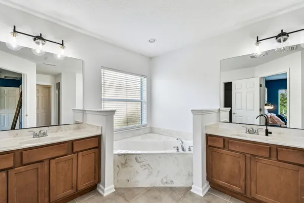 a spacious bathroom with a granite countertop tub sink and mirror