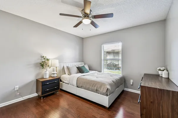a view of a hallway with wooden floor and a chandelier