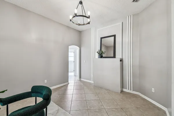 a hallway with white cabinets and wooden floor