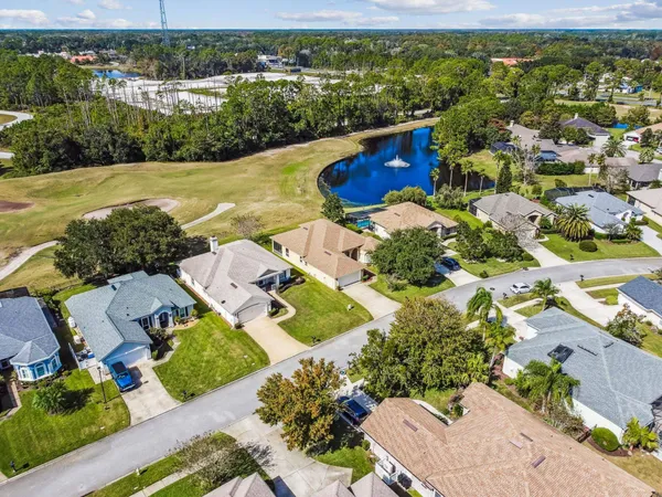 an aerial view of a house with a garden and lake view