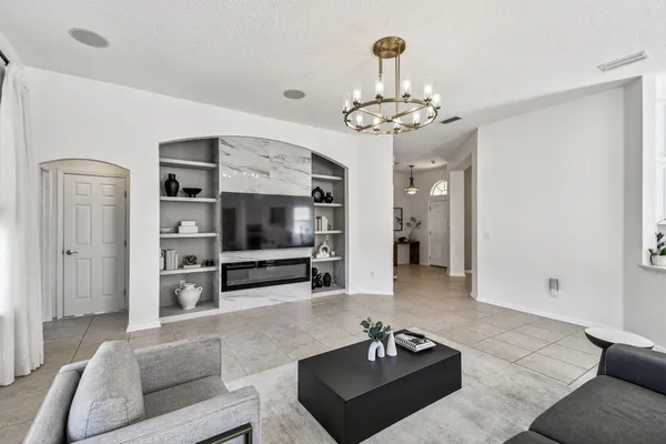 a living room with furniture a chandelier and a dining room