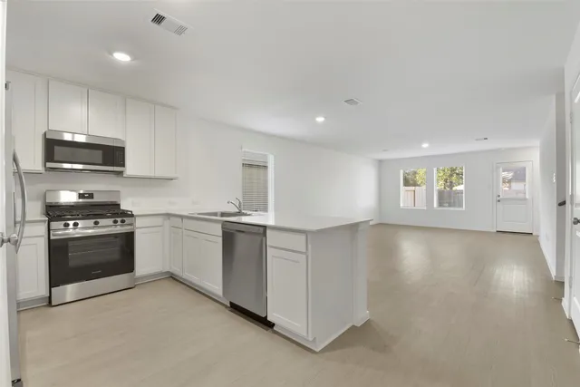 a kitchen with stainless steel appliances granite countertop a stove a sink and a refrigerator