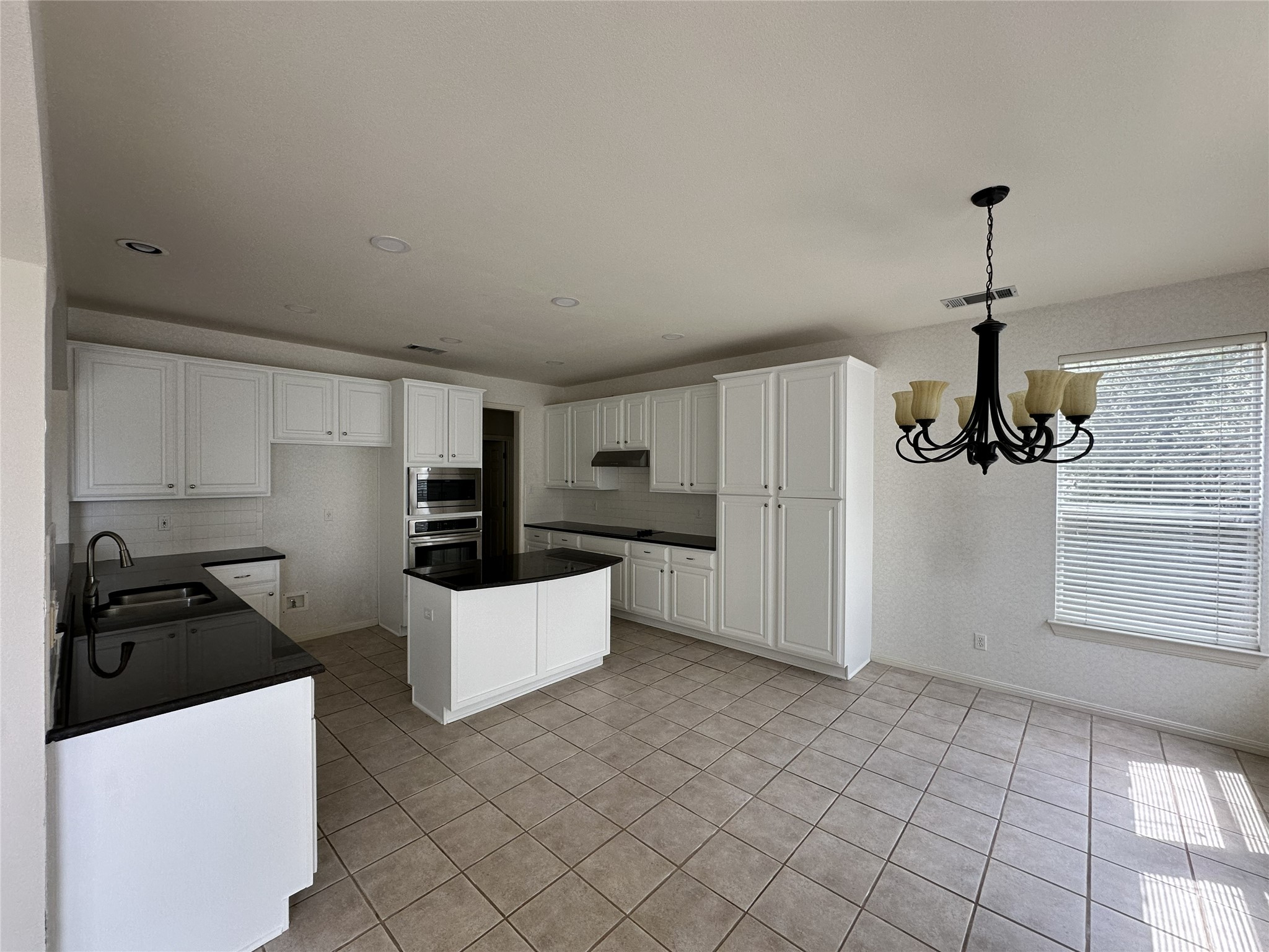 9405 Ashton Ridge Austin, TX 78750 - Photo 10 of 22 A well-lit kitchen with sleek dark counters and an inviting eat-in area for everyday meals.