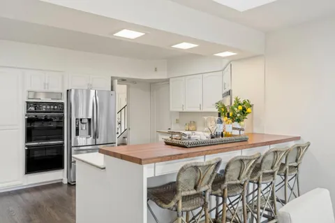 a kitchen with granite countertop a table chairs stove and cabinets