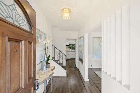 a view of a hallway with wooden floor and staircase