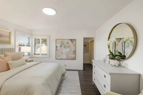 a living room with furniture a mirror and a large window