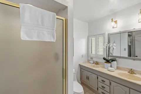 a bathroom with 2 sink toilet and a mirror