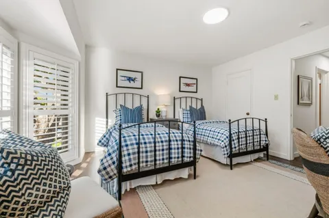 a bedroom with three beds and a window