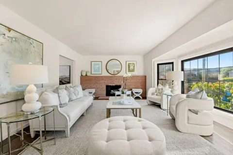 a living room with furniture fireplace and a large window