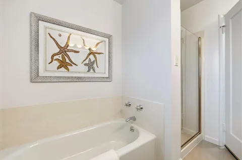 a white bath tub sitting next to a white wall