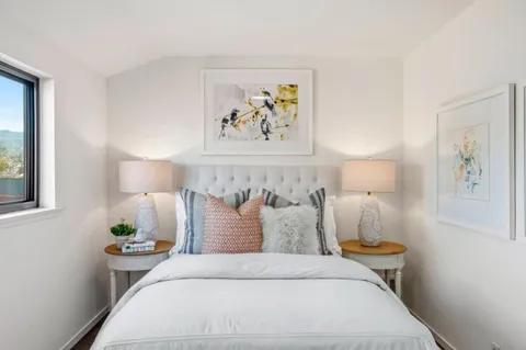 a bed room with a bed and a painting on the wall