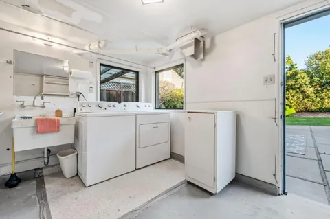 a utility room with cabinets washer and dryer
