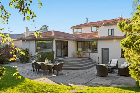 a view of a house with swimming pool and sitting area