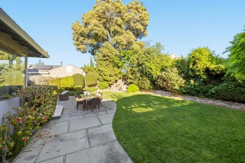a view of a patio with table and chairs and potted plants