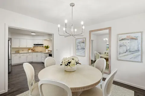 a dining room with furniture a chandelier and wooden floor