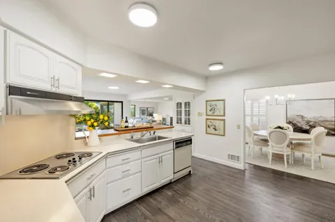 a kitchen with a sink cabinets and wooden floor