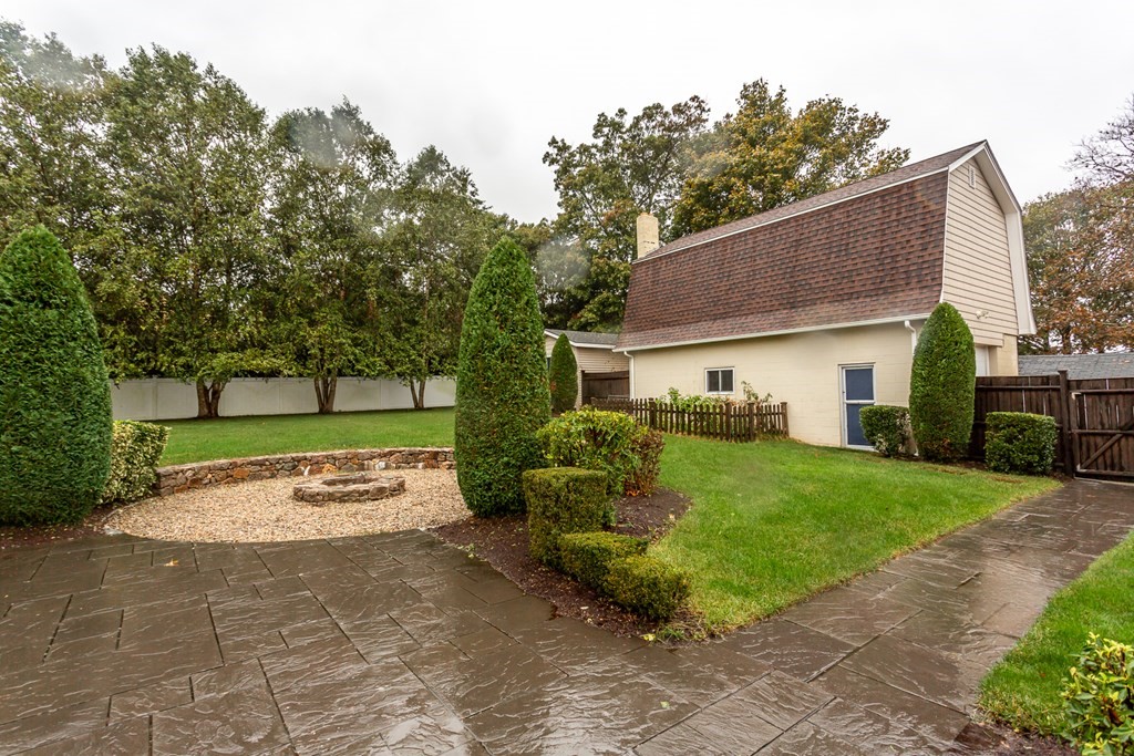 398 Chicago Street Fall River, MA 02721 - Photo 17 of 26 a view of a white house with a yard plants and a lawn chairs
