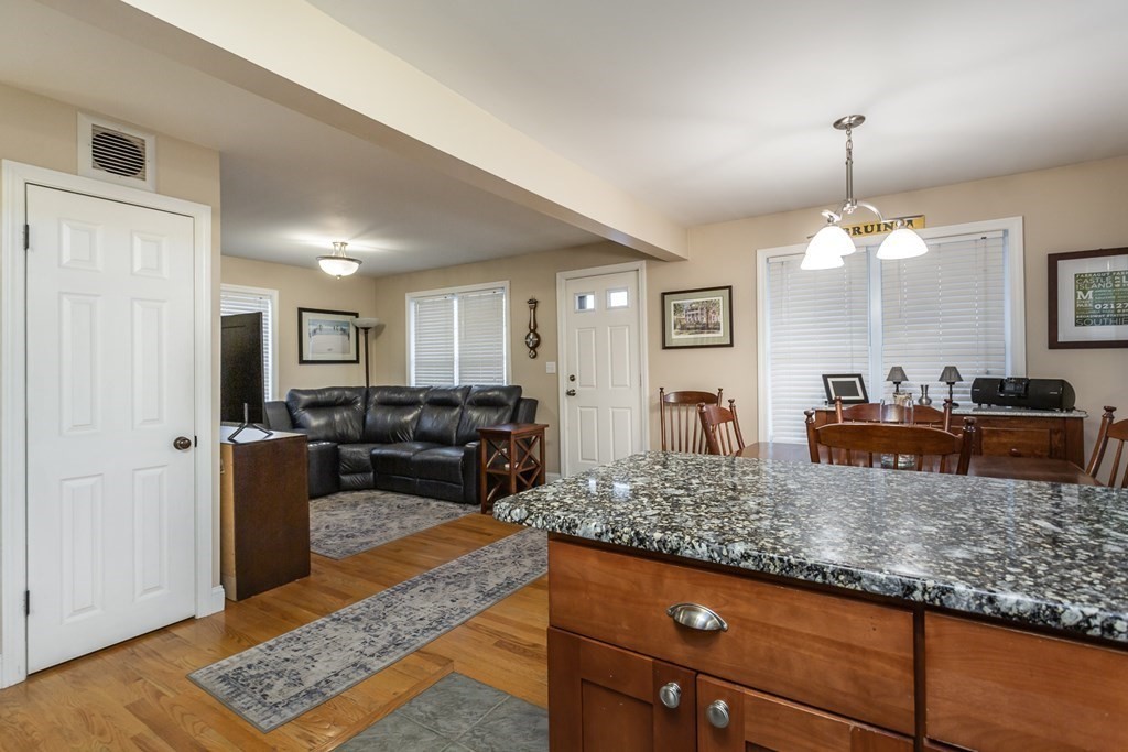 398 Chicago Street Fall River, MA 02721 - Photo 5 of 26 a living room with kitchen island granite countertop furniture and a chandelier