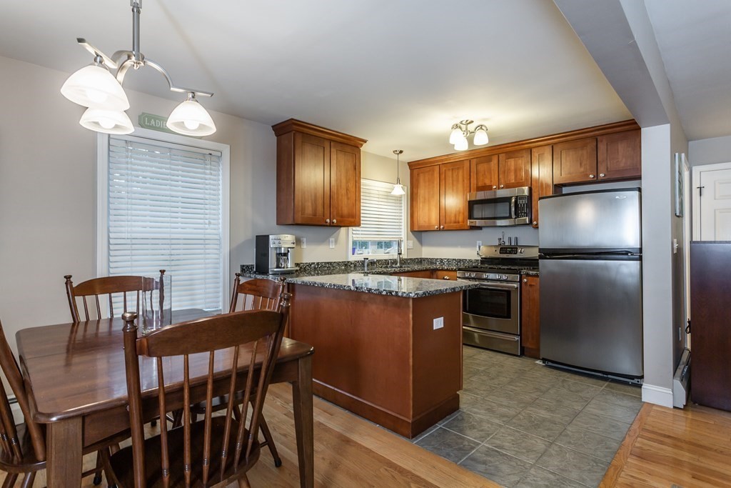 398 Chicago Street Fall River, MA 02721 - Photo 6 of 26 a kitchen with granite countertop a stove refrigerator dining table and chairs