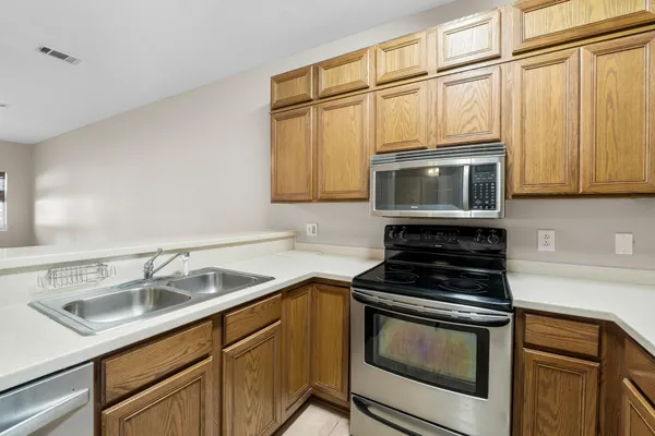 a kitchen with stainless steel appliances granite countertop a sink stove and microwave