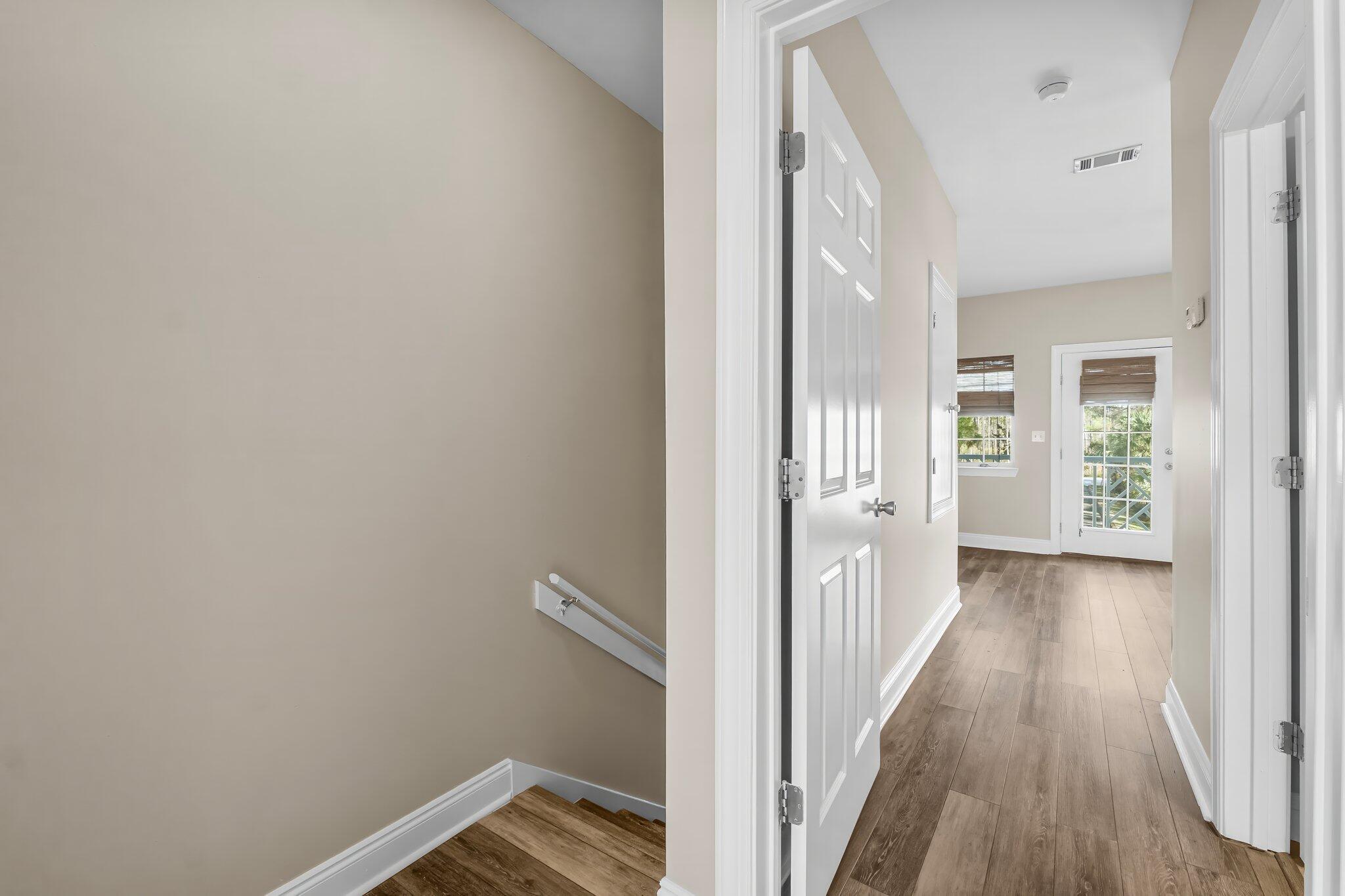 254 South Co Highway 393, Unit 2 Santa Rosa Beach, FL 32459 - Photo 18 of 45 a view of a hallway with wooden floor and a bathroom