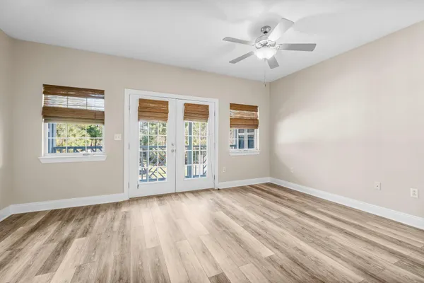 an empty room with wooden floor and windows