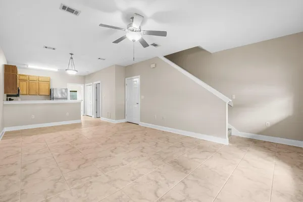 a view of a big room with wooden floor and a ceiling fan