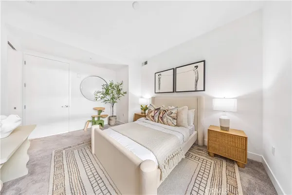 a bedroom with a bed couch and paintings on the wall