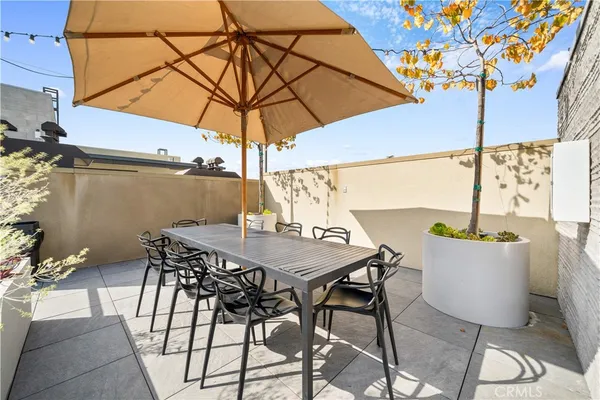 a view of a patio with a table and chairs and potted plants