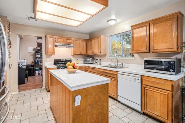 a kitchen with stainless steel appliances granite countertop a sink stove and a refrigerator