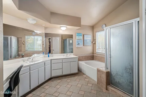 a bathroom with a tub a sink and mirror