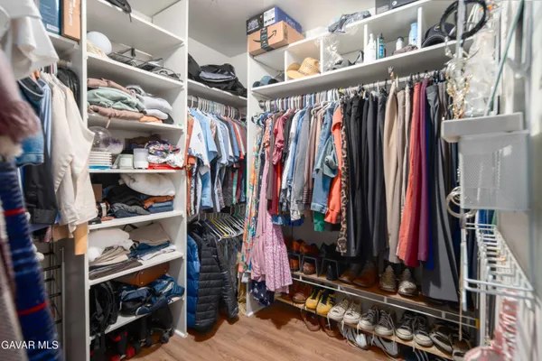 a view of walk in closet with clothes and shoes