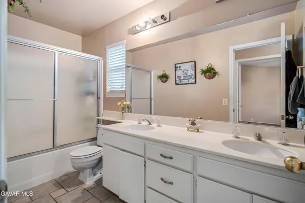 a bathroom with a sink toilet double vanity and shower