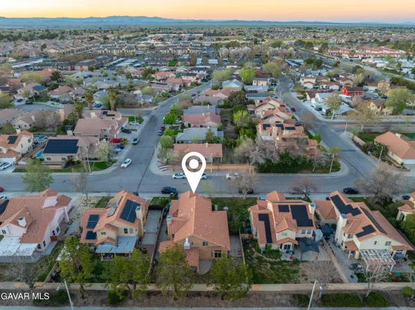 an aerial view of residential houses with outdoor space and parking
