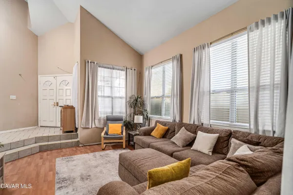 a living room with furniture and large windows