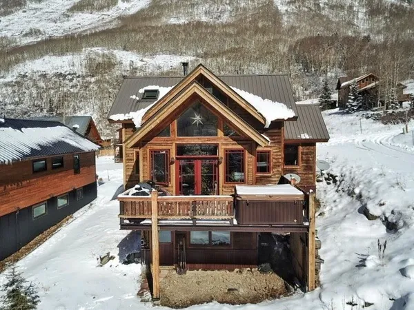 a view of a dining room with furniture a chandelier and wooden floor