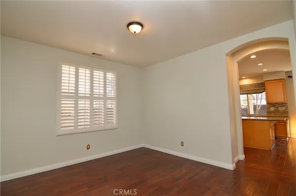 an empty room with wooden floor and a window