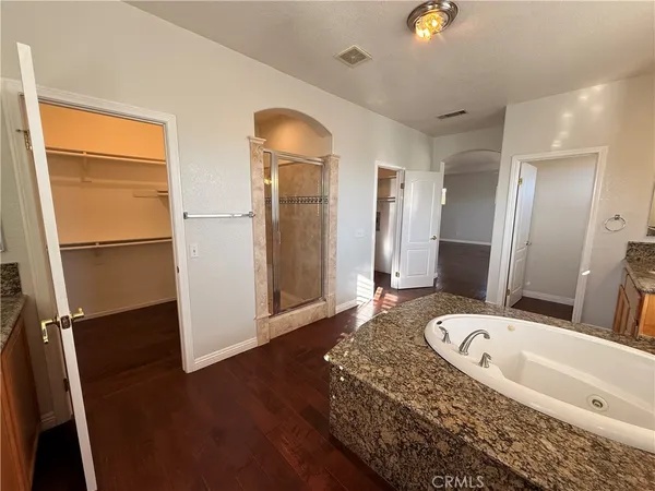 a bathroom with a granite countertop sink a mirror and a bathtub