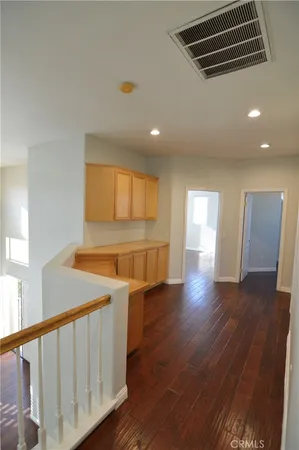 a view of an empty room with wooden floor and windows