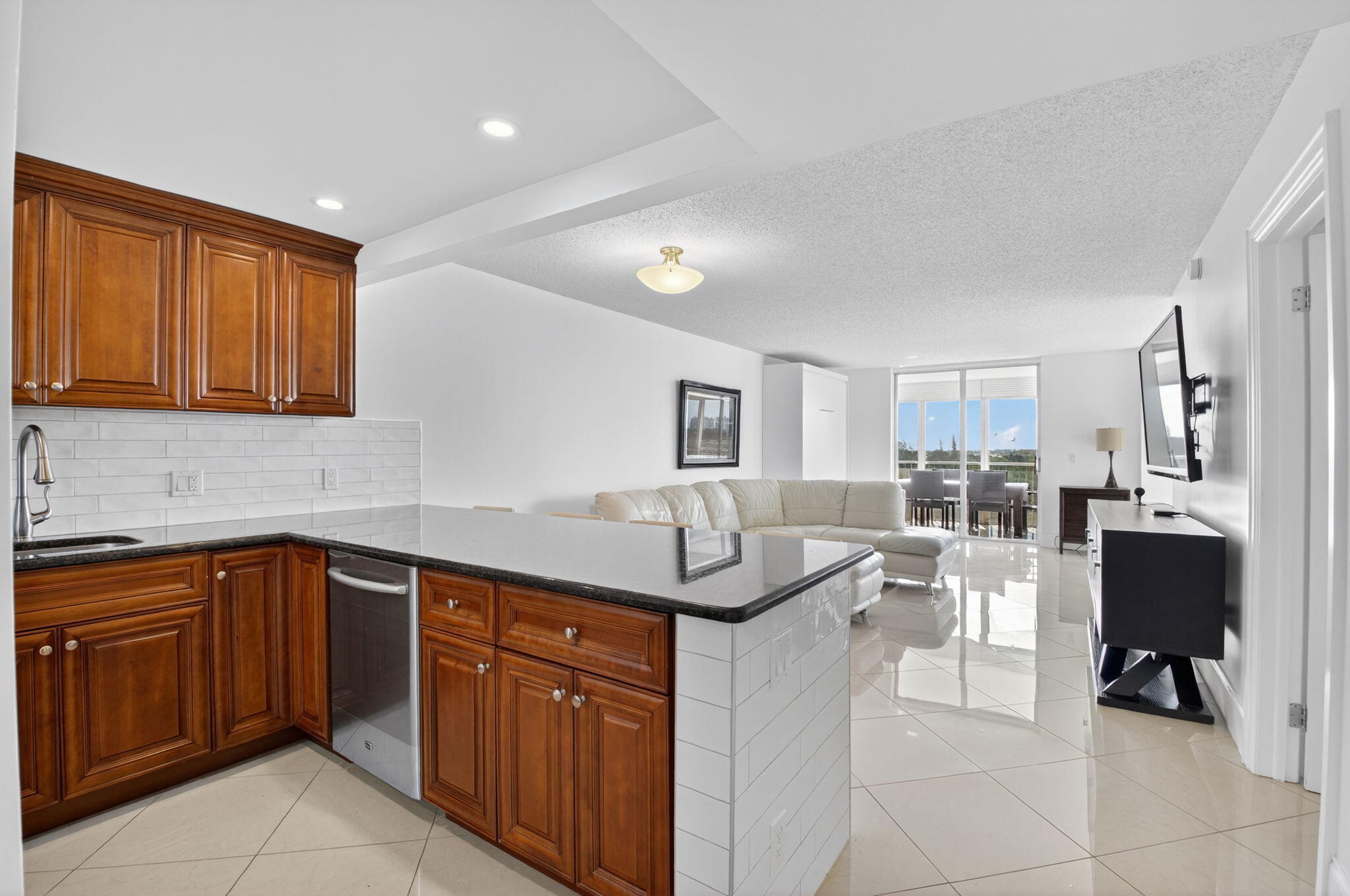 5500 Northwest 2nd Avenue, Unit 718 Boca Raton, FL 33487 - Photo 7 of 34 a kitchen with granite countertop a sink and cabinets