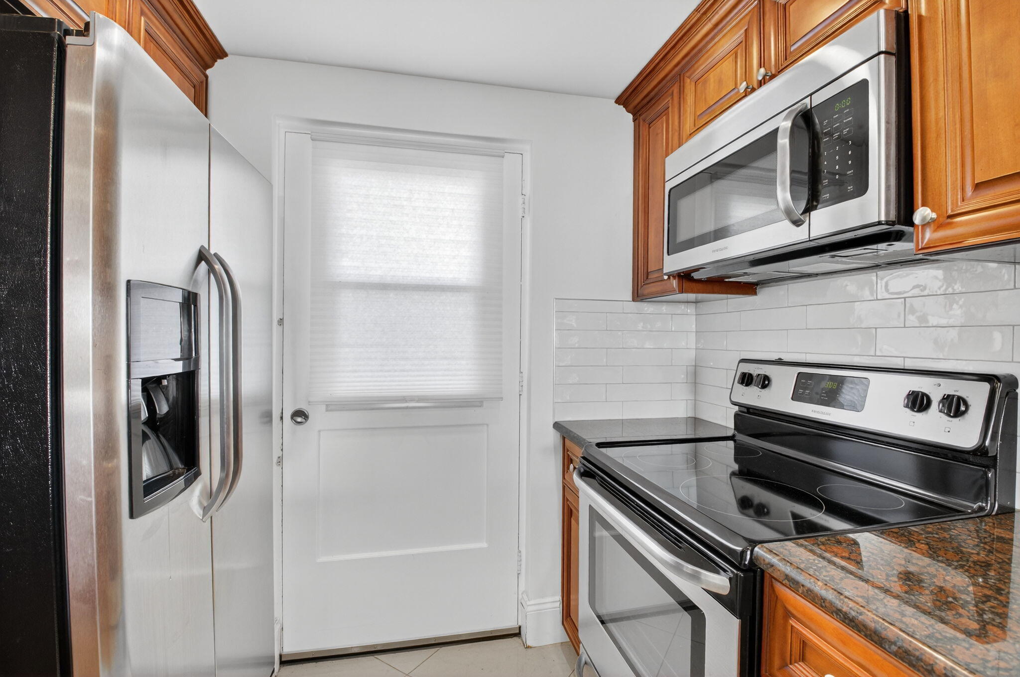 5500 Northwest 2nd Avenue, Unit 718 Boca Raton, FL 33487 - Photo 10 of 34 a kitchen with stainless steel appliances a stove a microwave and a refrigerator
