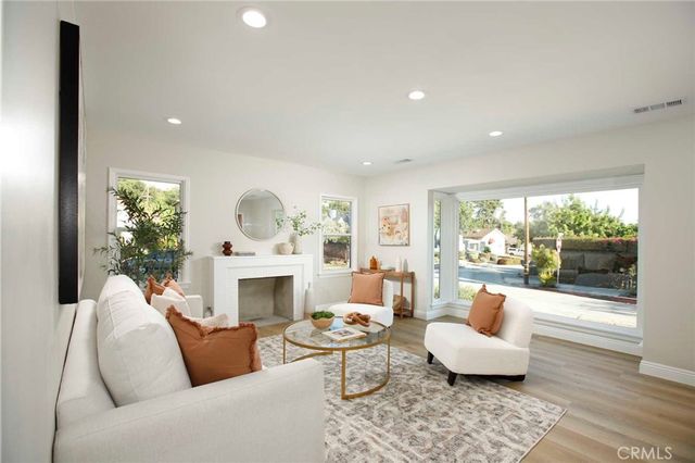 a living room with furniture fireplace and a large window