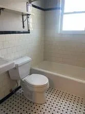 a white bath tub sitting next to a white toilet and a sink