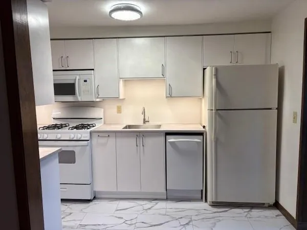 a kitchen with a refrigerator sink stove and cabinets
