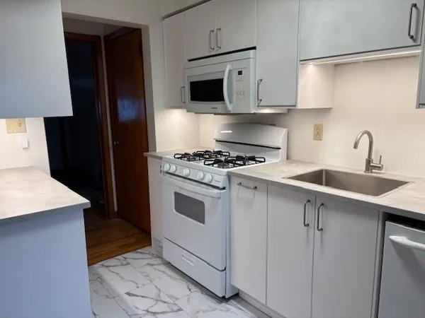 a kitchen with cabinets and white appliances