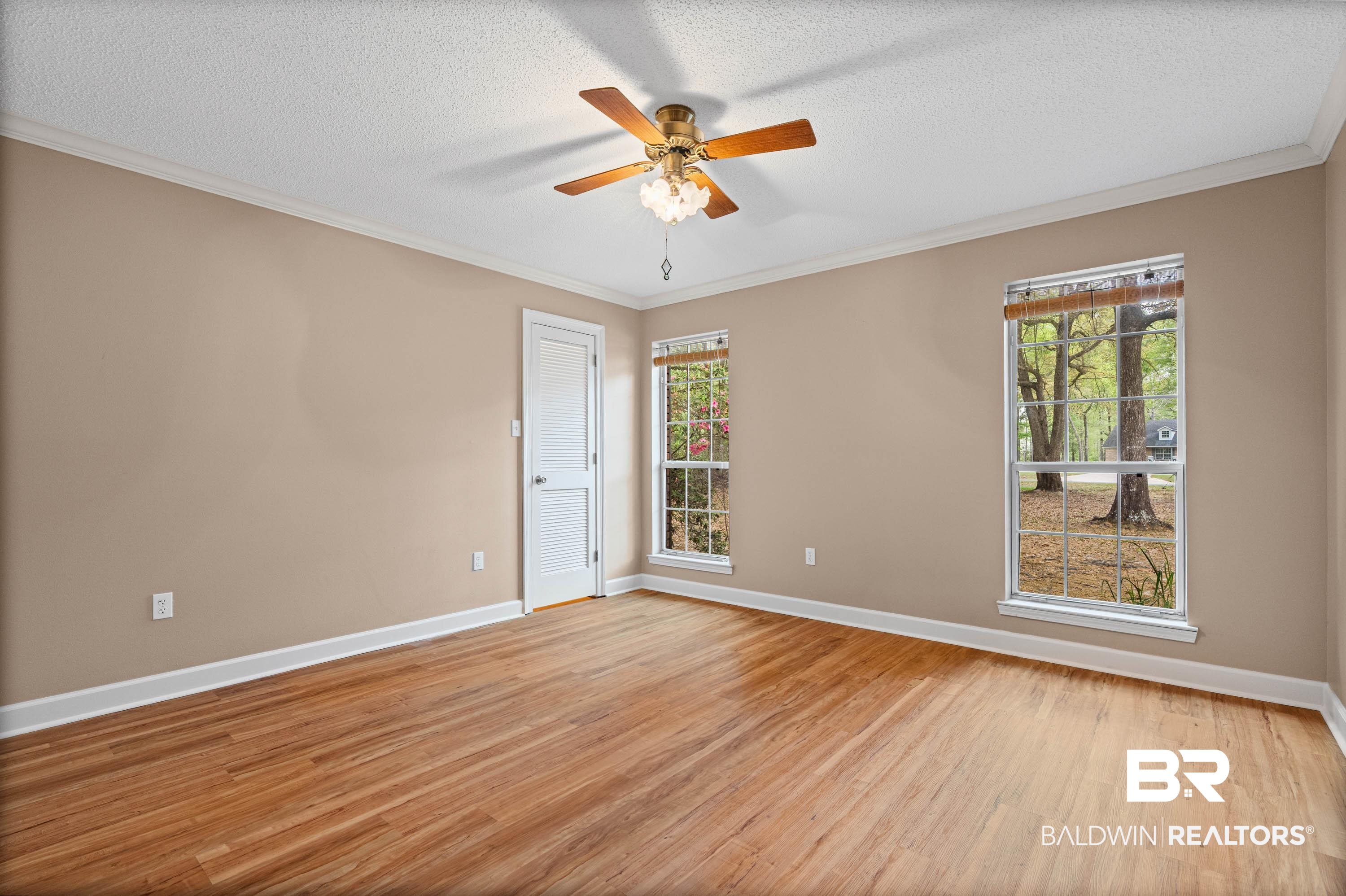 10140 Lakeview Road Bay Minette, AL 36507 - Photo 18 of 35 bedroom with crown molding, a ceiling fan, light wood-style flooring, and a textured ceiling