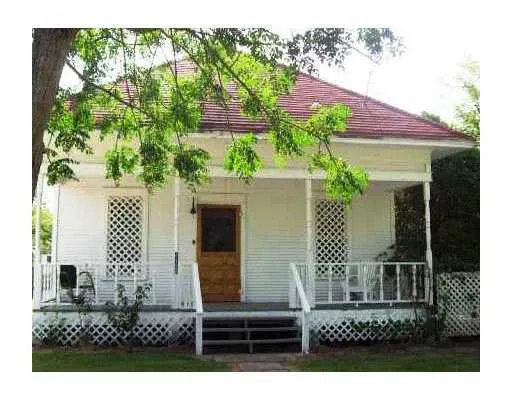 a view of backyard of a house with a bench